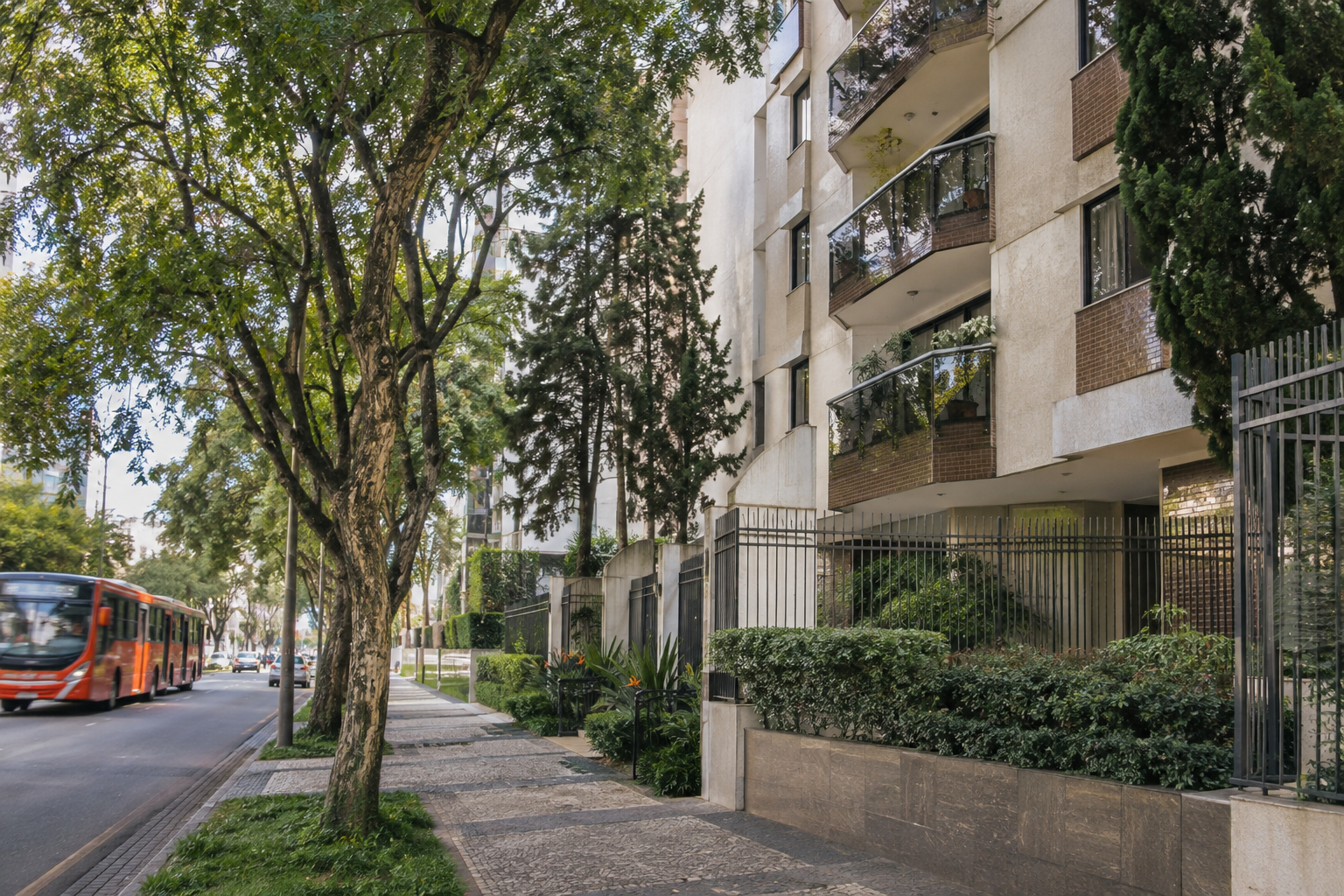Edifício residencial em rua arborizada com transporte coletivo próximo.